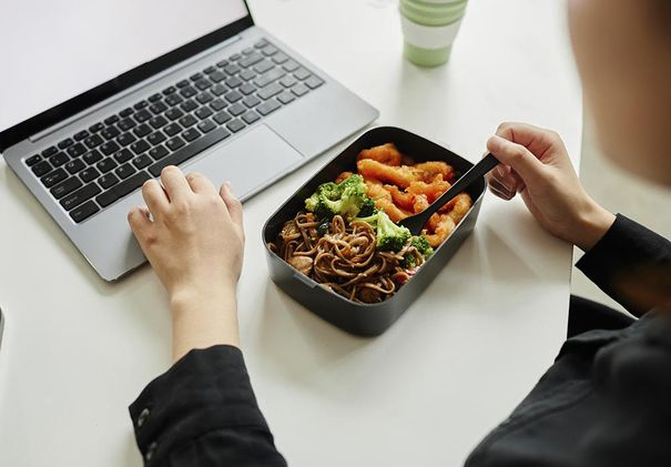 Persona con computador y comida